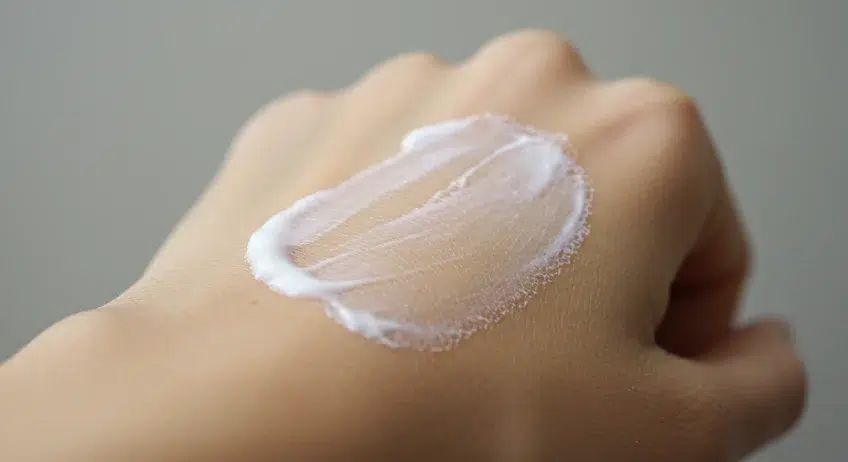 고혼진 검버섯 크림을 손등에 바른 모습. 아이보리색 크림이 흰 피부 위에 도톰하게 발라져 있는 클로즈업 이미지.