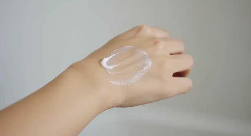 고혼진 뉴트리션 크림을 손등에 펴 바르며 질감과 흡수력을 확인하는 장면. 제품의 실제 사용감을 보여주는 이미지.